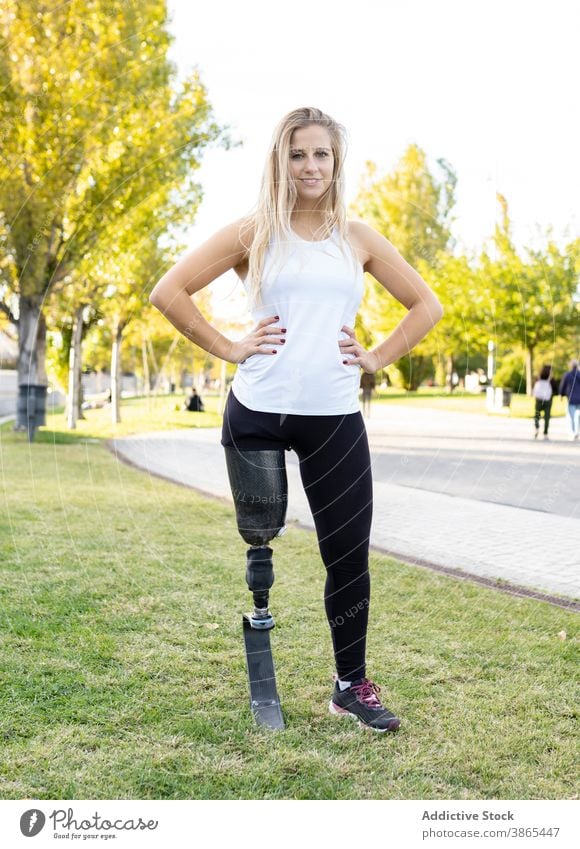 Fröhliche Sportlerin mit Beinprothese bei der Vorbereitung zum Training paralympisch Läufer Prothesen Frau Bionik künstliches Glied Athlet Großstadt vorbereiten