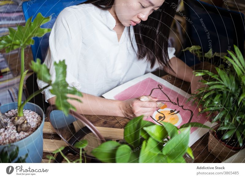 Ethnische Frau malt mit Aquarell zu Hause Farbe Künstler Malerei Anstreicher Pinselblume kreativ Kunst Kunstwerk Vorstellungskraft ethnisch asiatisch hölzern