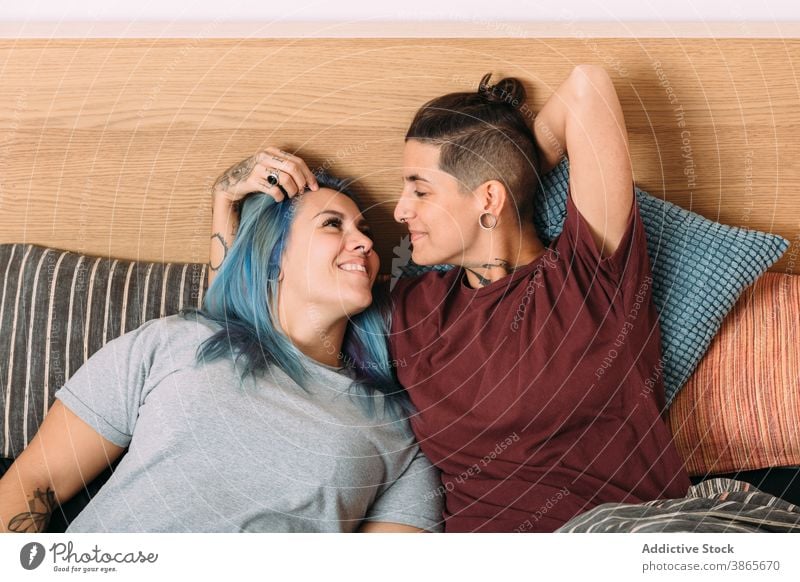 Junges lesbisches Paar umarmt auf dem Bett Frauen Kuss Liebe Glück Angebot Partnerschaft Freundin Schlafzimmer heimwärts androgyn Bonden Zusammensein Zuneigung