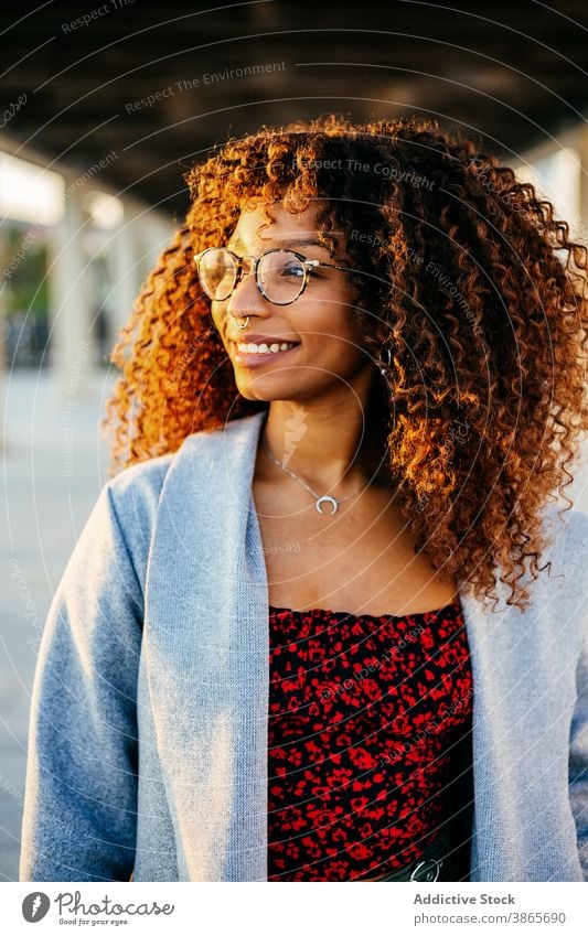 Stilvolle ethnische Frau in überdachter Passage Straße Großstadt Dach ruhen Durchgang Outfit Lächeln modern jung urban trendy schwarz Afroamerikaner