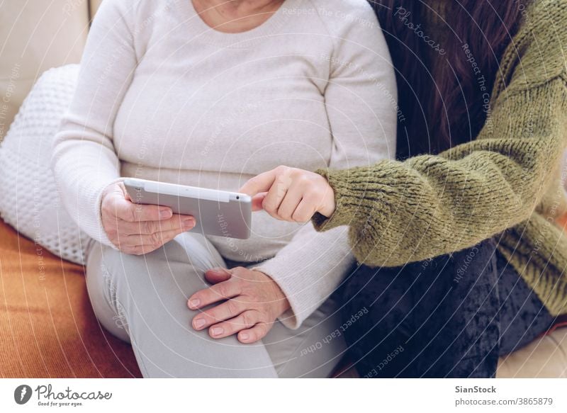Tochter hilft ihrer älteren Mutter mit der Tablette Senior online jung Frau Hände Erwachsener Person Arzt Frauen verwenden digital zeigen weiß