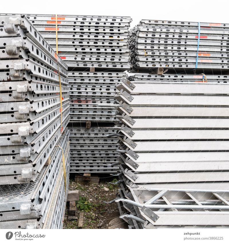 Mehrere Stapel aus Baugerüstteilen Baubedarf Wiederholung Lagerplatz grau