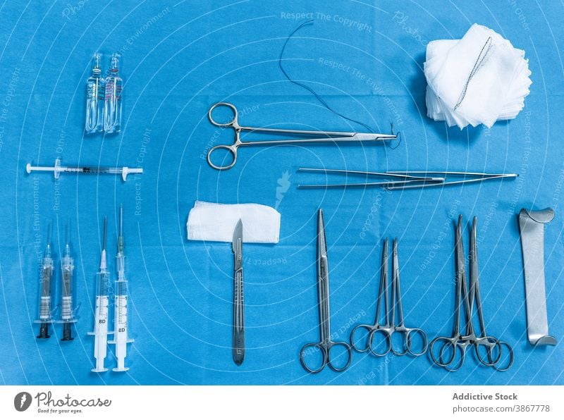 Set mit verschiedenen chirurgischen Hilfsmitteln auf blauem Tisch Chirurgie Werkzeug Instrument Kulisse Bausatz medizinisch professionell Vorrat rostfrei