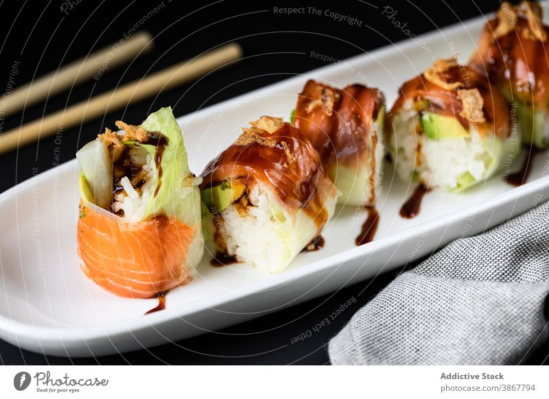 Leckere Brötchen mit Rüben und Soße rollen Asiatische Küche Sushi lecker teriyaki Saucen dienen Essstäbchen Orientalisch Lebensmittel frisch schmackhaft