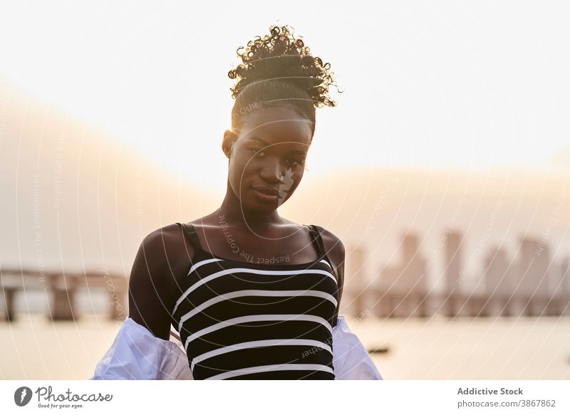 Ruhige schwarze Frau steht auf Stadt Böschung bei Sonnenuntergang MEER Stauanlage ruhig besinnlich sich[Akk] entspannen Windstille Sonnenlicht urban jung