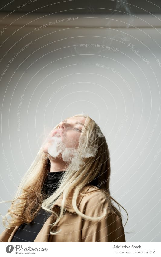 Junge Frau raucht e-Zigarette im Studio e Zigarette Raps Rauch Atelier Verdunstung Stil cool Nikotin Raucherin Habitus selbstbewusst jung schlecht ungesund