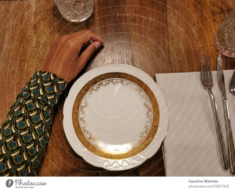 Der Arm einer Frau auf dem gedeckten Tisch, die auf das Essen wartet. Glas Häusliches Leben Design Stil Farbfoto Ernährung Teller gedeckter Tisch Porzellan