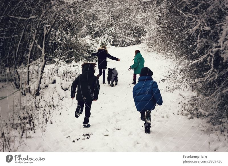 springende Kinder auf einem verschneiten Weg Winterurlaub zugeschneit ein Kind sein Spielen Kindheit Schneelandschaft Vorschulkind Kinderbetreuung Wintersport