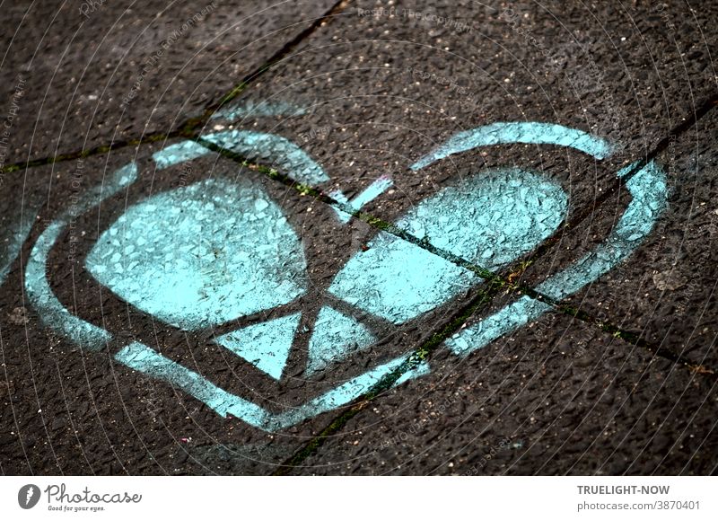 Das blaue Herz. Das kalte Herz. Das Herz aus Stein. Das gespaltene Herz. Das Herz aus Eis. Ein Graffiti Herz in Blau und Schwarz auf graue Betonplatten gesprüht.