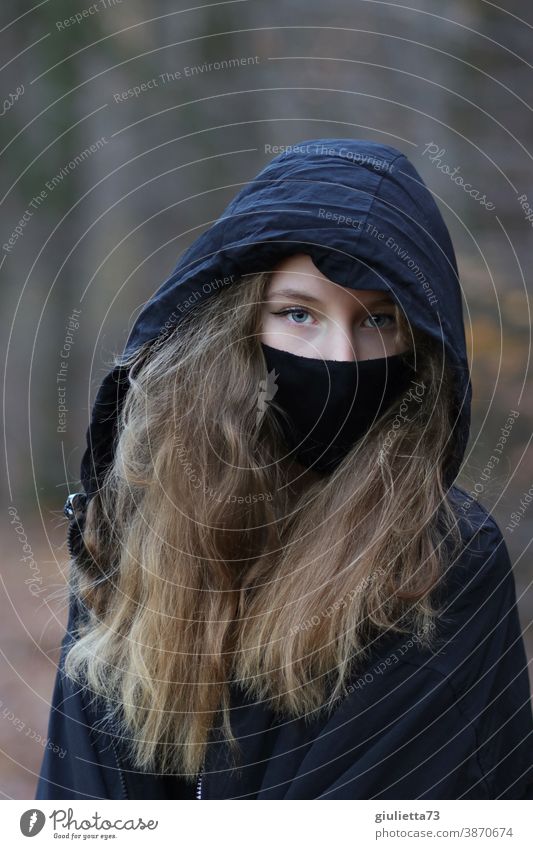 Porträt eines Teenager Mädchens in schwarz, mit Kapuze und Mund-Nasen-Bedeckung/ Maske I corona thoughts Grippe covid-19 düster Epidemie COVID Infektionsgefahr