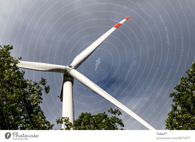 eine Windkraftanlage im Wald in der Sonne Windrad Turbine Elektrizität Energie Ökostrom Unwetter Wolken moderne Windkraftanlage