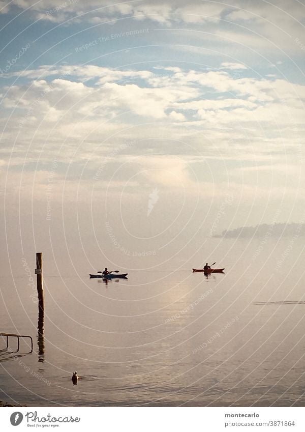 Zwei Paddler auf dem Bodensee im November Außenaufnahme kalt Stille Herbst neblig ruhig diesig Düster Farbfoto Tag Sicht stimmung Paddelboote Boot Himmel wolken