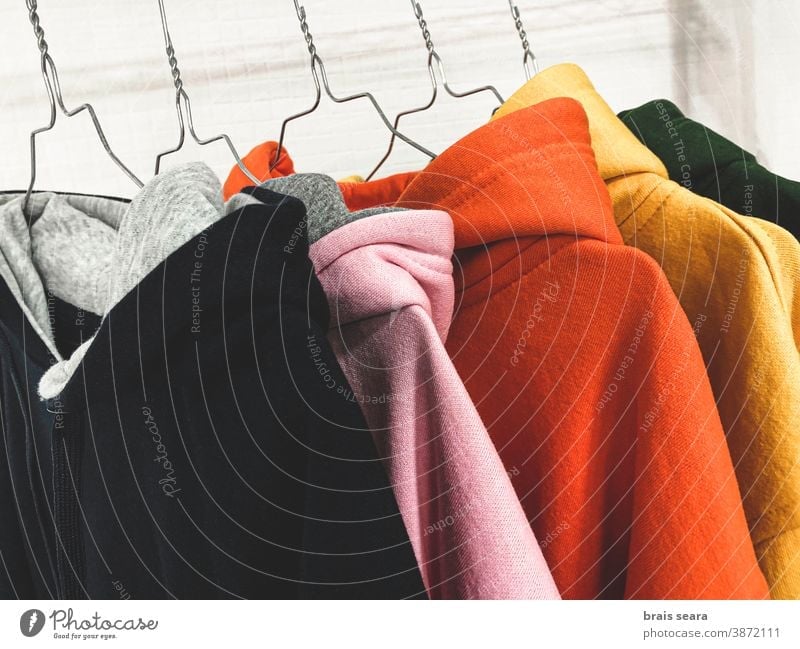 Mehrfarbige Sweatshirts auf der Garderobe Mode Farben Kleidung Sauberkeit Wäscherei mehrfarbiger Hintergrund Kaufhaus Werkstatt heimwärts Eleganz Rippeln