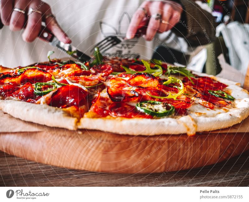 Schmackhafte und köstliche italienische Salamipizza. Pizza Gabel Messer geschmackvoll jalape Käse Tomate Tomatensauce Holzplatte Tisch Essen lecker Abendessen