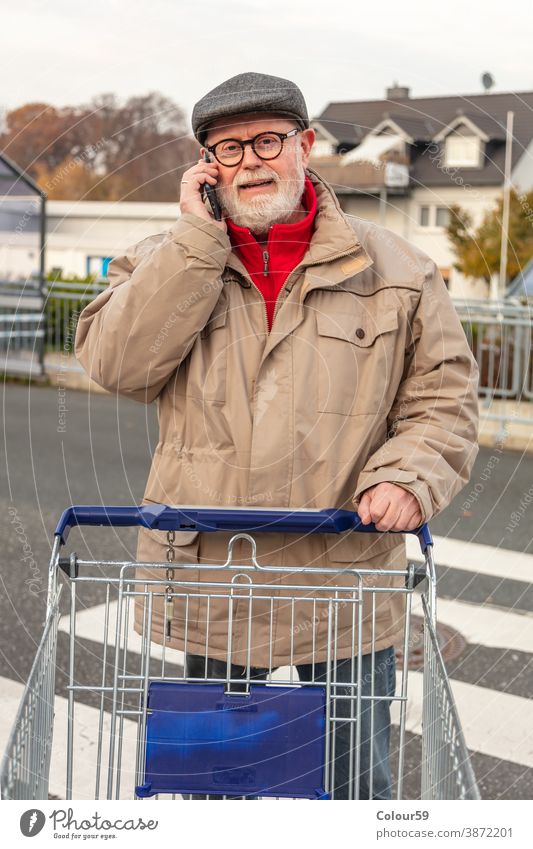 Seniorin mit Wintertuch beim Telefonieren Verbraucher bezahlen Kaufhof attraktiv Käufer im Freien Lifestyle Markt Person Smartphone benutzend Funktelefon jung