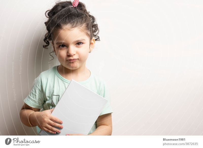 Kleines Mädchen hält ein Buch mit leerem Einband vor einer Körpermodellserie 268 Attrappe editierbar ersetzen. kleines Mädchen Beteiligung Körperfront blanko