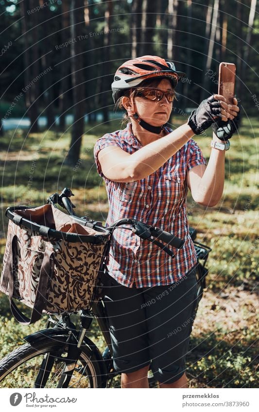 Aktive Frau verbringt freie Sommerferien in einem Wald auf einer Fahrradtour und fotografiert mit dem Smartphone Freude Freiheit fallen Erholung Abenteuer