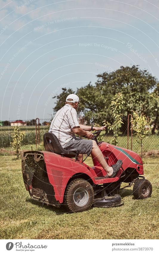 Mann mäht seinen Rasen mit einem Aufsitzrasenmäher Beruf Rasenmäher saisonbedingt geschnitten Trimmen Job Person entgittern Feld professionell