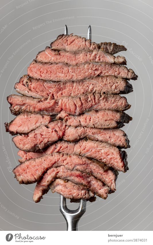 Scheiben eines Steaks auf grauem Hintergrund niemand black angus ribeye bbq prime Beef Fleischgabel aufgespießt steak steakscheiben hintergrund medium saftig