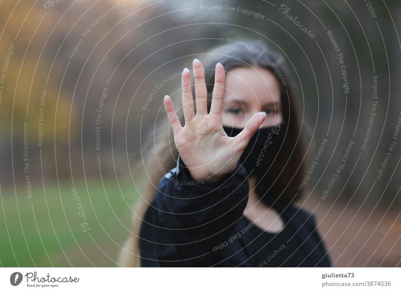 Teenager Mädchen symbolisiert: Nein - Stopp - Halt , indem es die Hand vor sich ausstreckt stopp Abstand Schutz Blick in die Kamera Vorderansicht Oberkörper