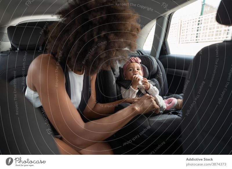 Schwarzer Mutter-Befestigungsgurt am Baby-Autositz PKW Sitz befestigen Gurt Schnallen Sie sich an Kleinkind Sicherheit sicher ethnisch schwarz Afroamerikaner