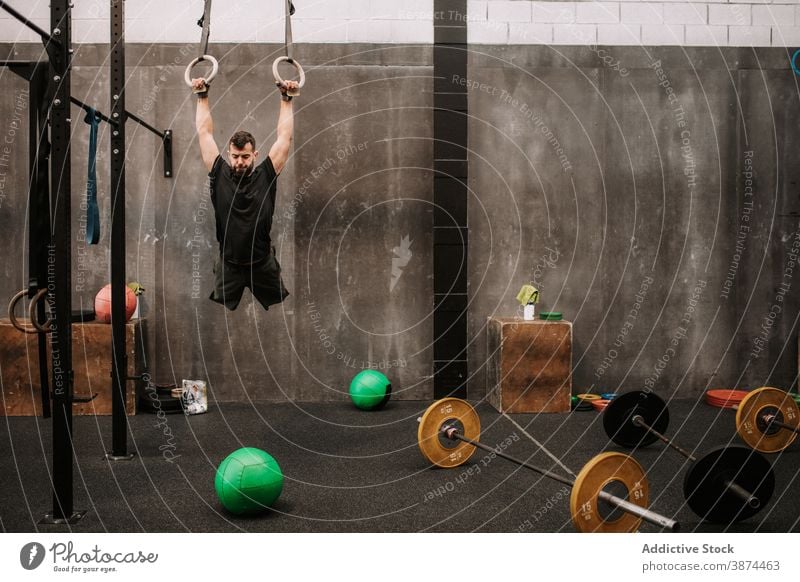 Muskulöser Mann trainiert an Gymnastikringen gymnastisch Ring operativ Training stark Übung Athlet Fitnessstudio männlich Sportbekleidung Kraft passen Ausdauer