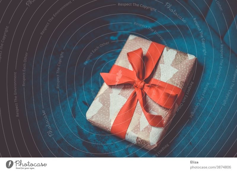 Weihnachtsgeschenk mit roter Schleife auf blauem Hintergrund Geschenk Weihnachten verpackt weihnachtlich Heiligabend schenken Weihnachten & Advent Bescherung