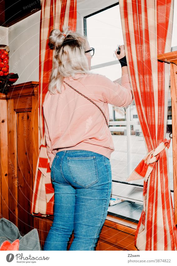 Junge Frau beim bemalen der Fensterscheiben in einem Gasthof gasthof deko dedorieren holz bayerisch innenraum gastraum restaurant stühle stube tische