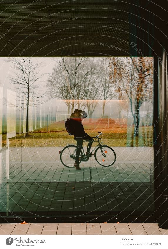 Selbstportrait eines Fotografen auf dem Fahrrad fahrrad fahrradfahren fotograf fotografieren spiegel scheibe fenster natur spiegelung herbst bäume warme farben