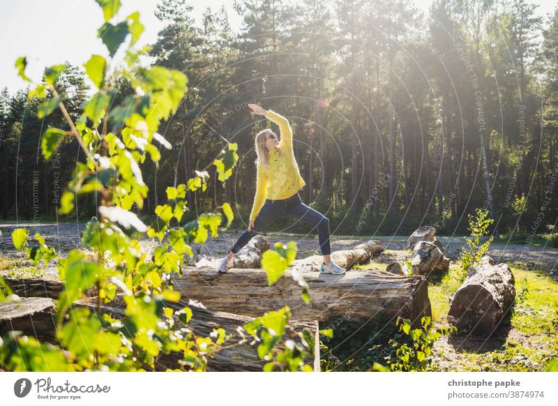 Frau macht Yoga auf Baumstamm im Wald grün Umwelt Natur Außenaufnahme Farbfoto Tag Sport Bewegung Blätter Landschaft Schönes Wetter Sonnenlicht