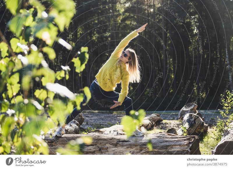 Frau macht Yoga auf Baumstamm im Wald grün Umwelt Natur Außenaufnahme Farbfoto Tag Sport Bewegung Blätter Landschaft Schönes Wetter Sonnenlicht