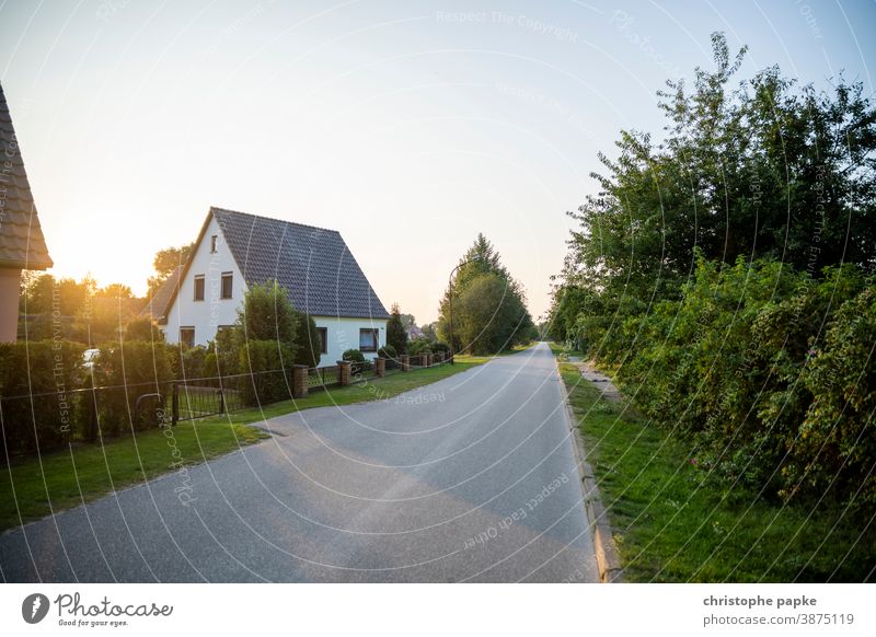 Haus in ländlicher Umgebung Einfamilienhaus Immobilie Eigenheim wohnen Weg Sonnenuntergang Sonnenlicht Menschenleer Häusliches Leben wohnen im grünen Gebäude