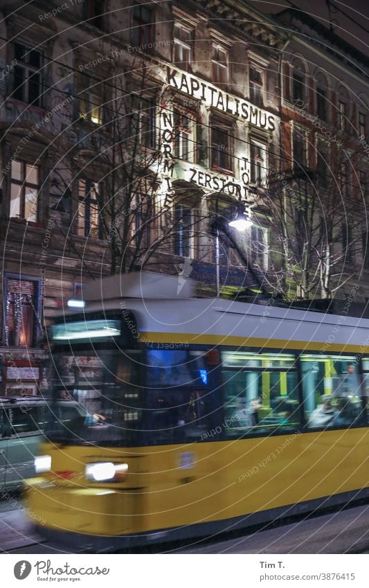 eine Straßenbahn fährt durchs Bild in der Kastanienallee bei Nacht Berlin Prenzlauer Berg kastanienallee Farbfoto Winter trambahn Außenaufnahme Kapitalismus
