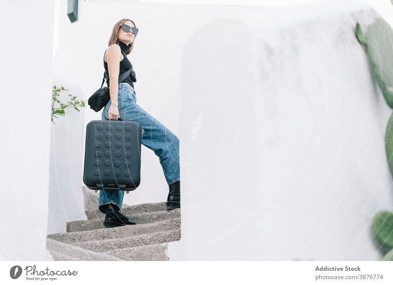 Weiblicher Reisender mit Koffer auf einer Treppe in der Stadt Sommer Urlaub Tourist Frau Großstadt urban Sommerzeit Sonnenbrille Gepäck nach oben Spaziergang