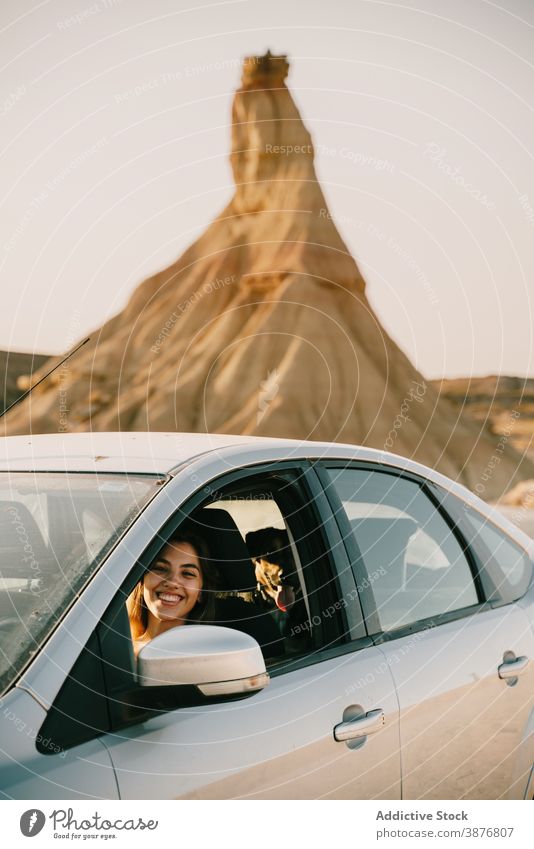 Fröhliche Frau sitzt im Auto in der Natur bardenas reales Reisender PKW Ödland Urlaub sonnig Automobil heiter Sightseeing Autoreise Spanien Tourist reisen