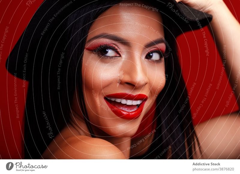 Lächelnde Frau mit roten Lippen im Studio rote Lippen Make-up Gesicht charmant Vorschein Hut Tastkopf Model heiter Optimist positiv Inhalt lebhaft pulsierend