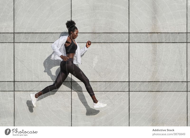 Schwarze schlanke Sportlerin beim Training in der Stadt springen Frau Übung Straße Großstadt Sprung Athlet ethnisch schwarz Afroamerikaner Sportbekleidung