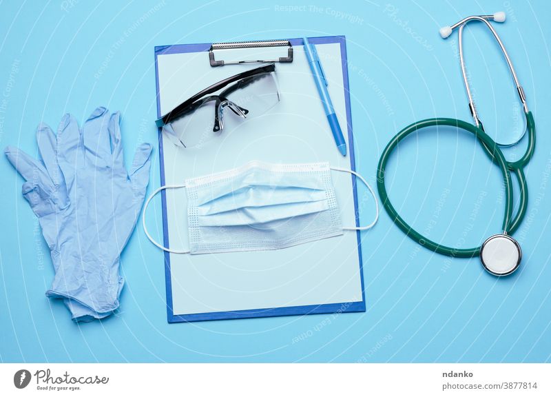 medizinische Einwegmaske, Kunststoffbrille und Stethoskop auf blauem Hintergrund Mundschutz Sanitäter Medizin niemand Pandemie professionell behüten Schutz