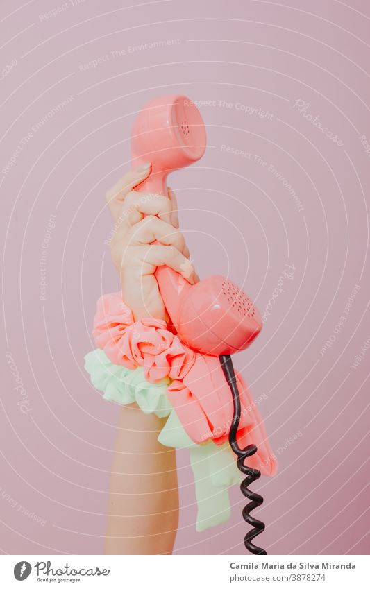 weibliche Hand hält ein altes rosa Telefon auf rosa Hintergrund. Antiquität Business Kabel Anruf Anruf für Sie klassisch Mitteilung Konzept Anschluss
