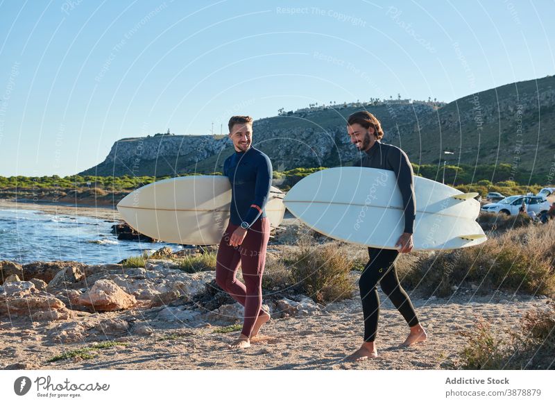 Männer mit Surfbrettern gehen am Strand entlang Surfer Spaziergang Holzplatte MEER Sonnenuntergang männlich Freund Freundschaft Meeresufer Natur nass Sommer