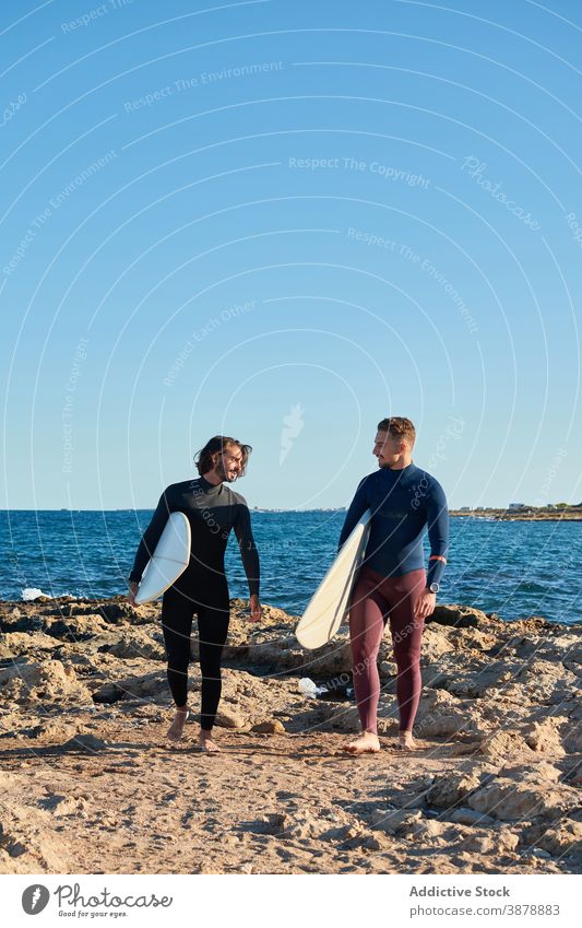 Männer mit Surfbrettern gehen am Strand entlang Surfer Spaziergang Holzplatte MEER Sonnenuntergang männlich Freund Freundschaft Meeresufer Natur nass Sommer