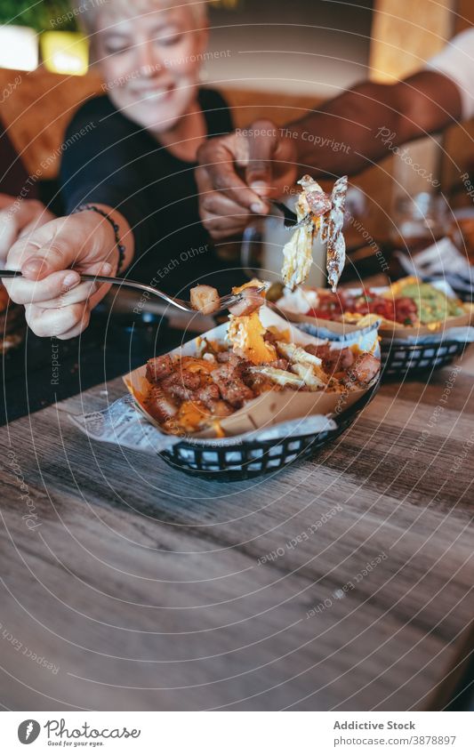 Gesellschaft von Freunden essen Fast Food im Café sich[Akk] sammeln Fastfood Zusammensein Unternehmen Kartoffel Käse Speck multiethnisch rassenübergreifend