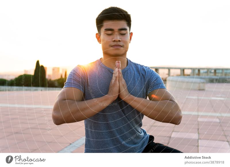 Zufriedener Mann meditiert in Baumpose bei Sonnenuntergang meditieren Yoga Gleichgewicht Stressabbau Achtsamkeit Baumhaltung Namaste Augen geschlossen Asana
