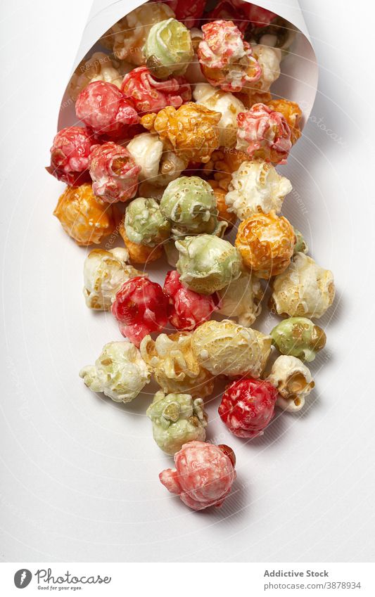 Leckeres knuspriges Popcorn auf weißem Tisch Popkorn farbenfroh süß Leckerbissen Snack Papier Zapfen lecker mehrfarbig Paket Haufen Lebensmittel Ernährung