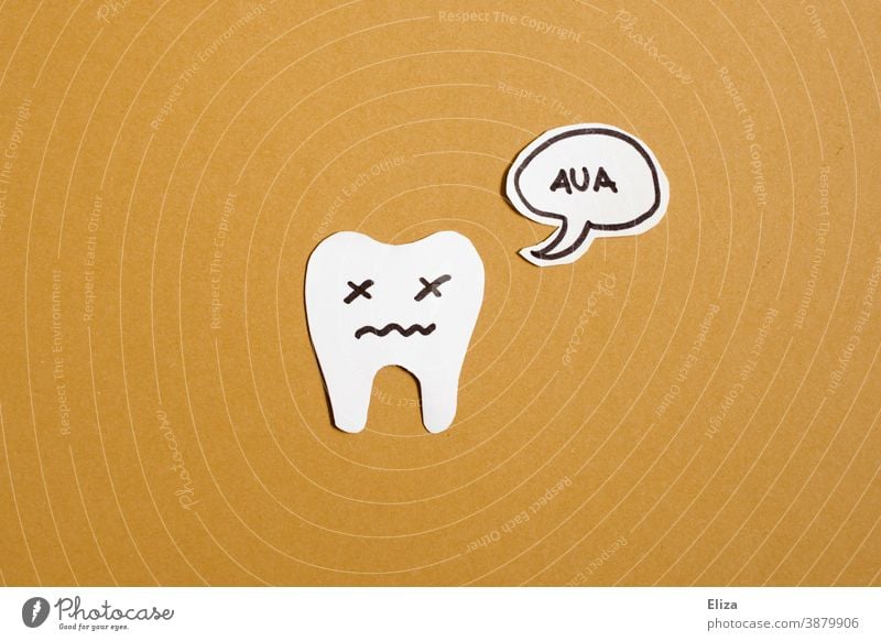 Ein Zahn mit einer Sprechblase auf der Aua steht. Konzept Zahnschmerzen. gelb Gesicht Zahnarztbesuch schmerzverzehrt Schmerzen haben Hintergrund neutral gemalt