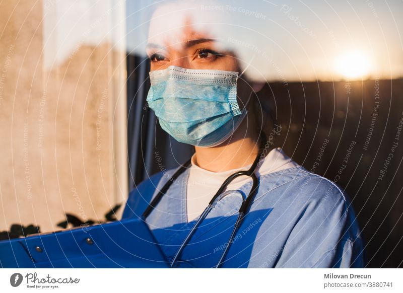 Junger Arzt schaut durch das Fenster Anspannung Pflege Klinik betroffen Korona Coronavirus COVID Kur niedergeschlagen Diagnostik älter emotional Gerät Gesicht