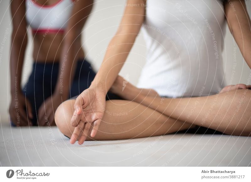Indische schwarz-weiße brünette Mädchen, die in Unterwäsche vor weißem Hintergrund Yoga/Sport/Übungen machen. Indischer Lebensstil Erwachsener asiatisch