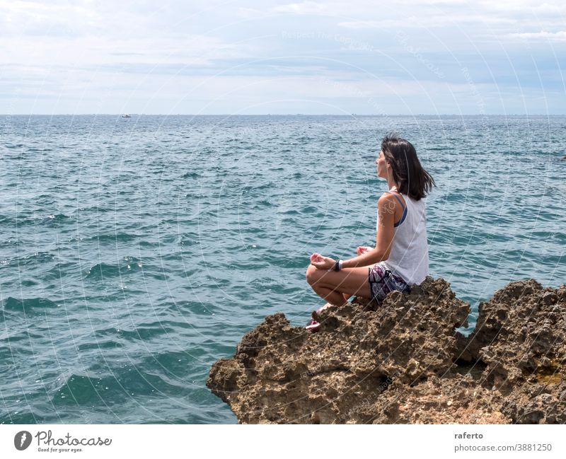 Schöne Frau praktiziert Yoga am Strand bei Sonnenaufgang Sitzen Felsen Wasser Meer MEER schön Feiertag Person Mädchen Lifestyle Natur eine Horizont Windstille