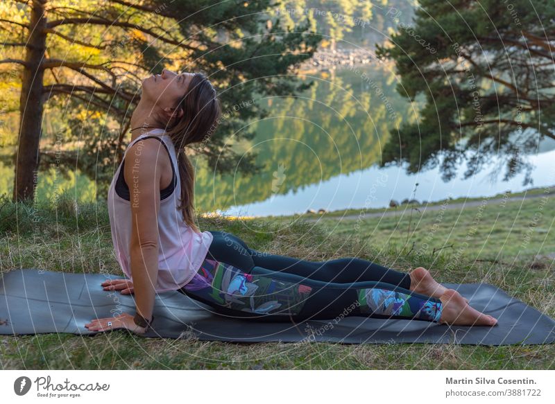 Frau praktiziert Yoga allein im Wald Rückenansicht Outdoor-Aktivität Junge attraktive Frau praktiziert Yoga, trainiert trainiert trainiert Frauen meditieren bei Sonnenaufgang allein.