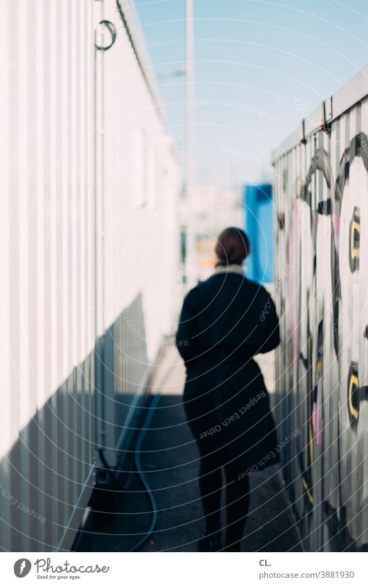 zwischen containern Container Frau Rückansicht anonym Identität Graffiti geheimnisvoll Bewegung gehen verfolgen allein Wege & Pfade draußen unscharf